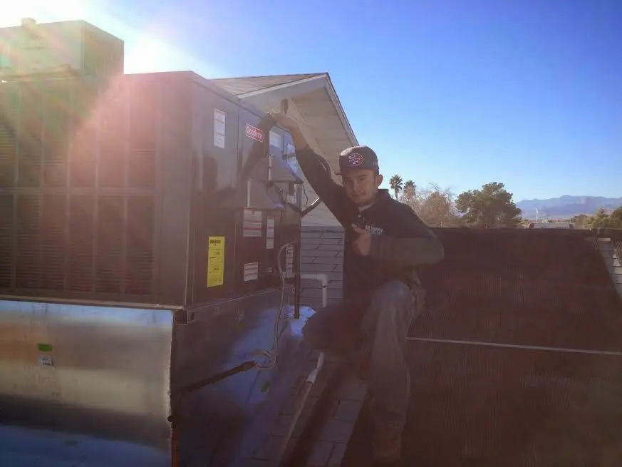 HVAC technician performing AC Tune-Up on a rooftop unit in West Park